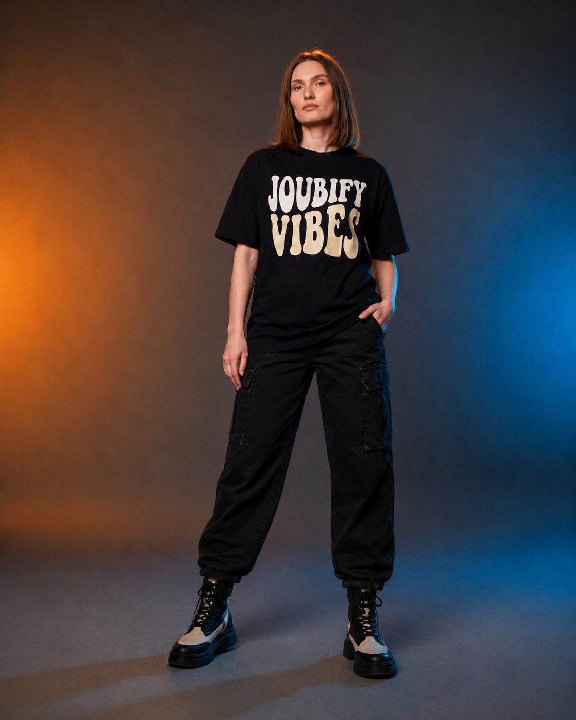 Nonna wearing the Joubify Vibes oversized black tee with black cargo pants under amber and blue studio light