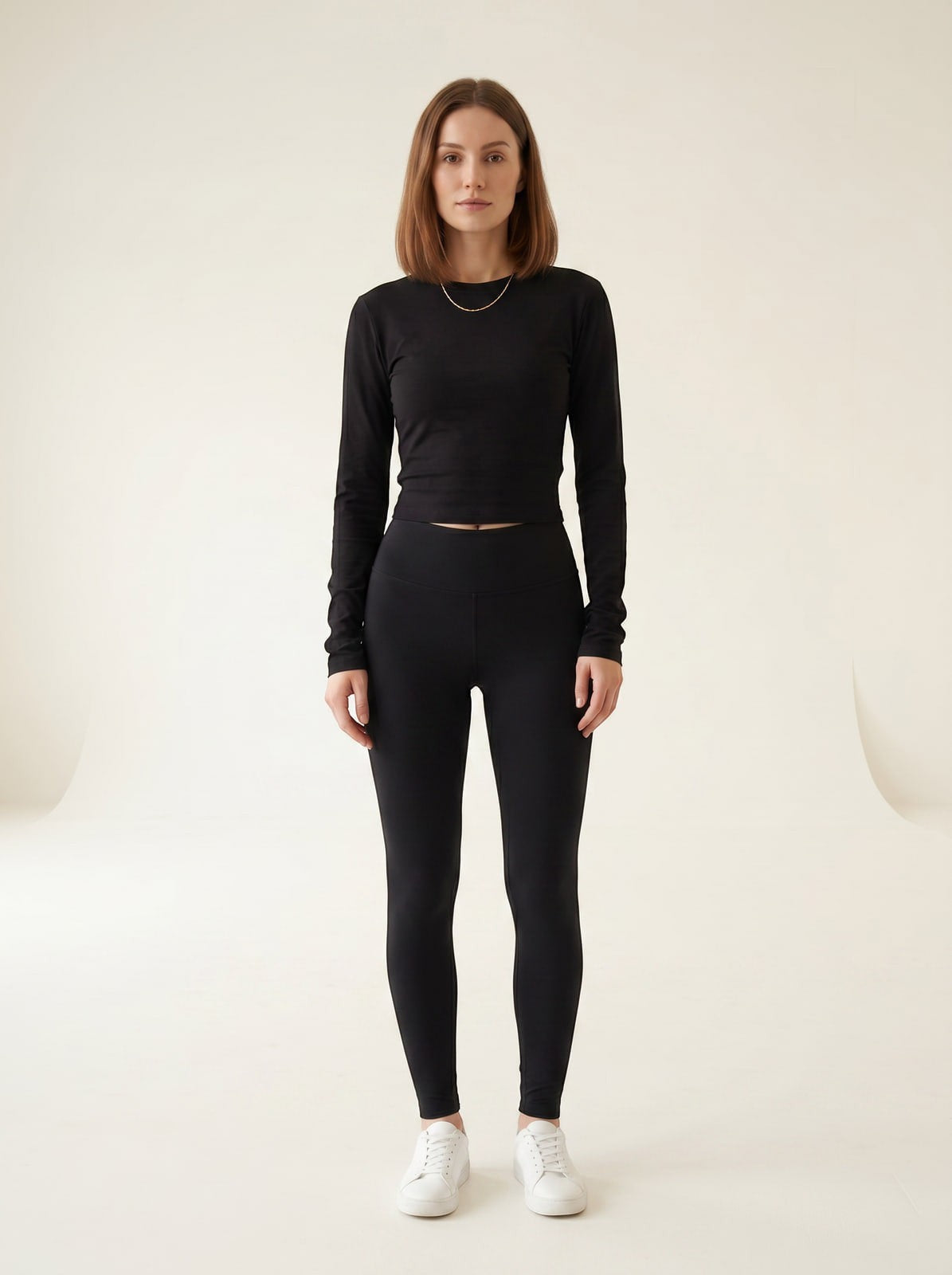 Model wearing the Joubify black long sleeve cropped jersey top with ruching and matching leggings