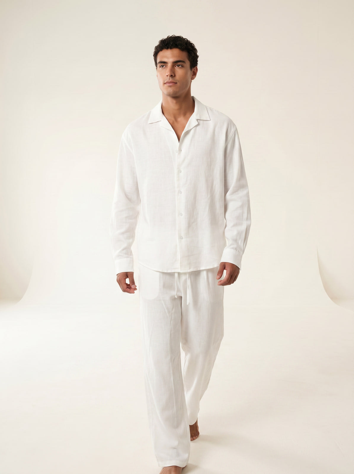Joubie mid-stride wearing the full white Joubify linen outfit, editorial studio shot