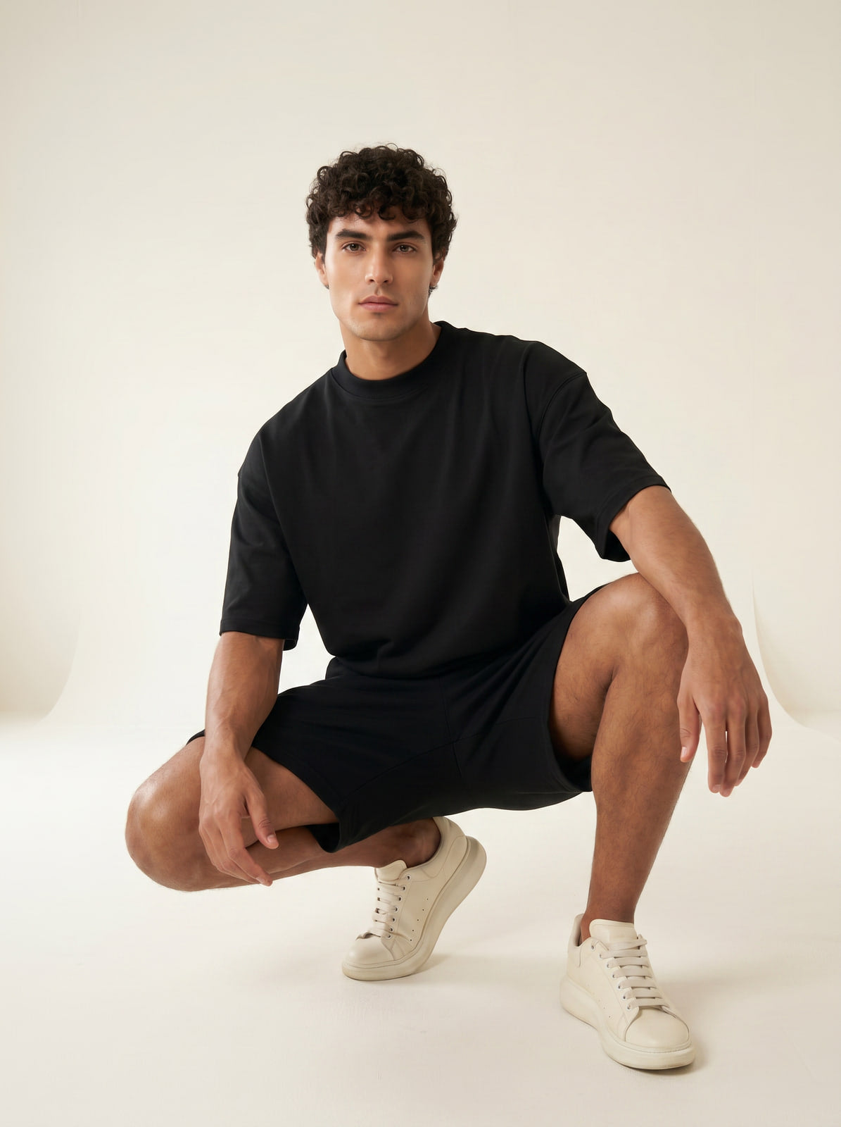 Joubie in a crouched pose wearing the oversized black heavyweight T-shirt